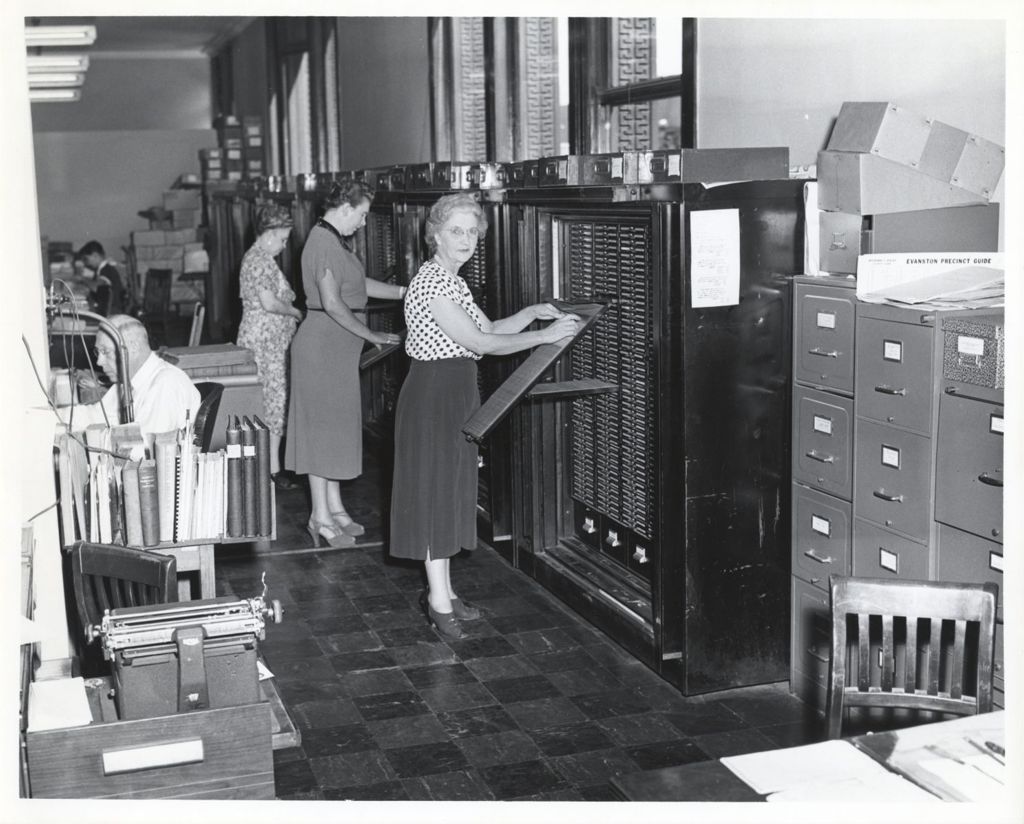 Women search records in a card file