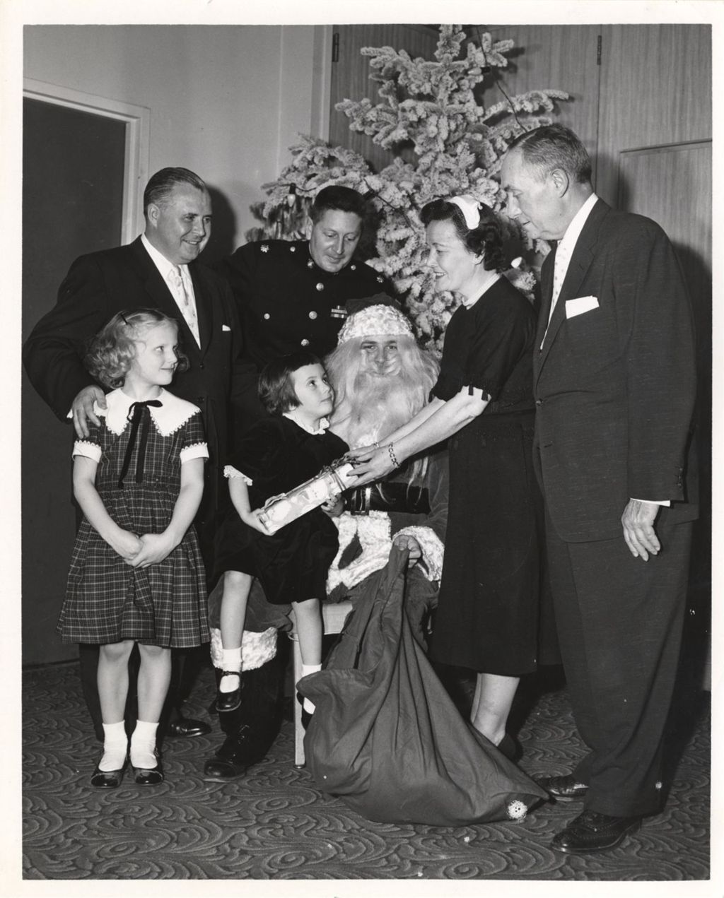 Miniature of Eleanor Daley gives a gift to a child on Santa's lap