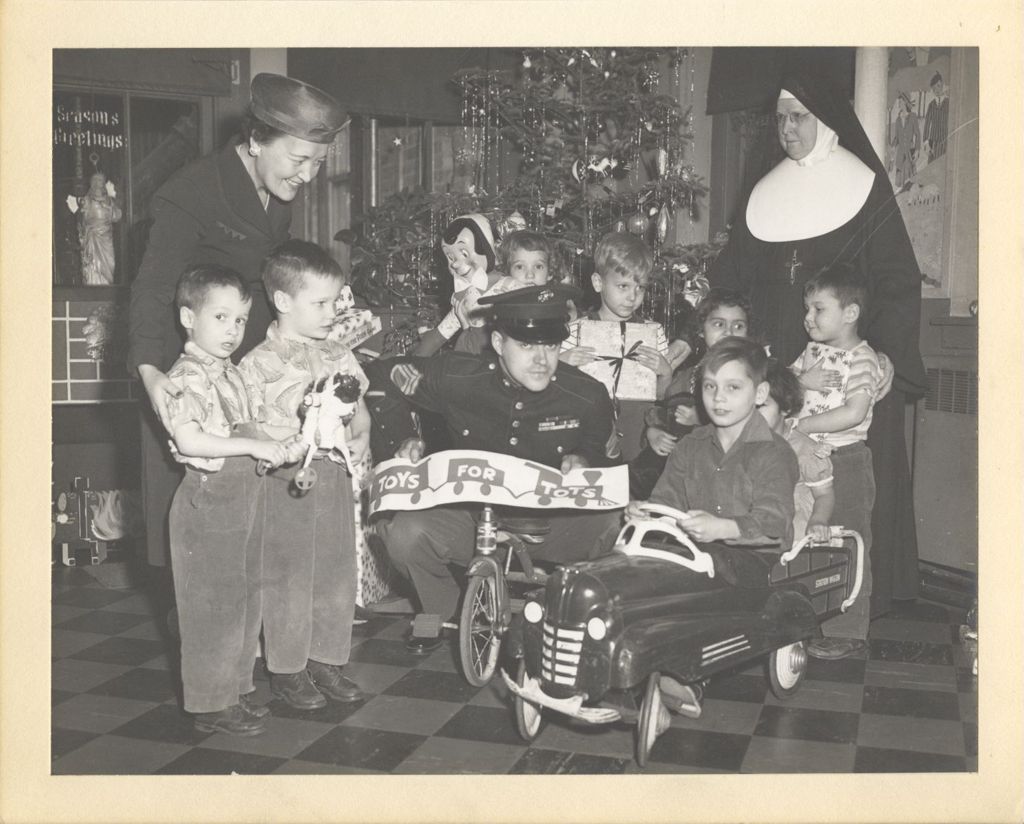 Miniature of Eleanor Daley and others with children receiving toys
