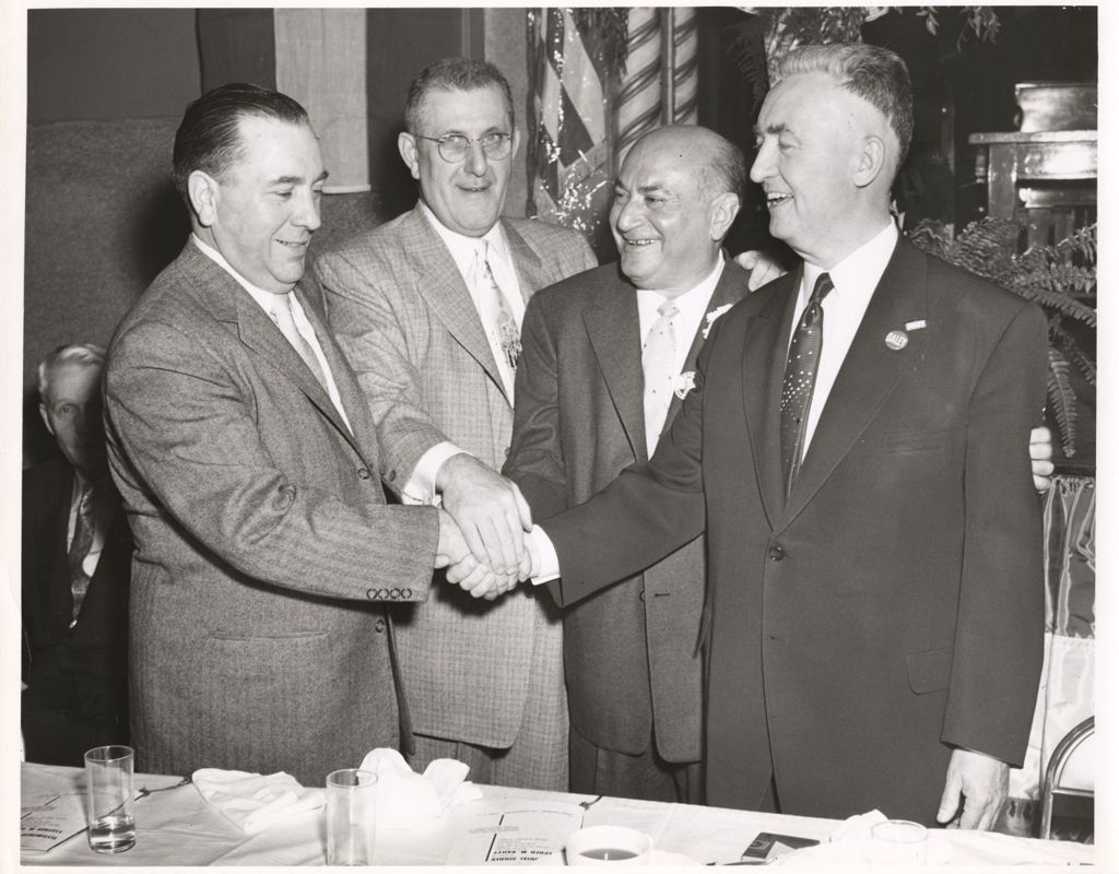 Richard J. Daley, Morris B. Sachs and others clasp hands