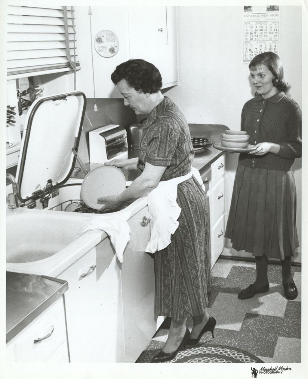 Eleanor Daley loading a dishwasher with Patricia Daley