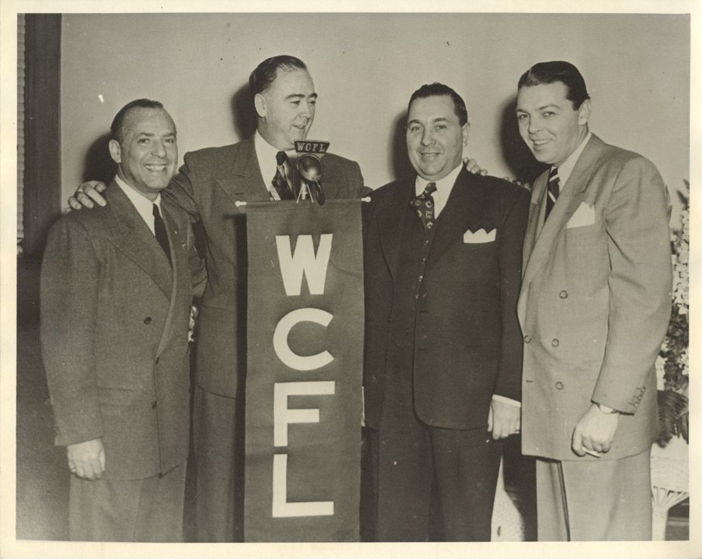 William A. Lee at microphone with others
