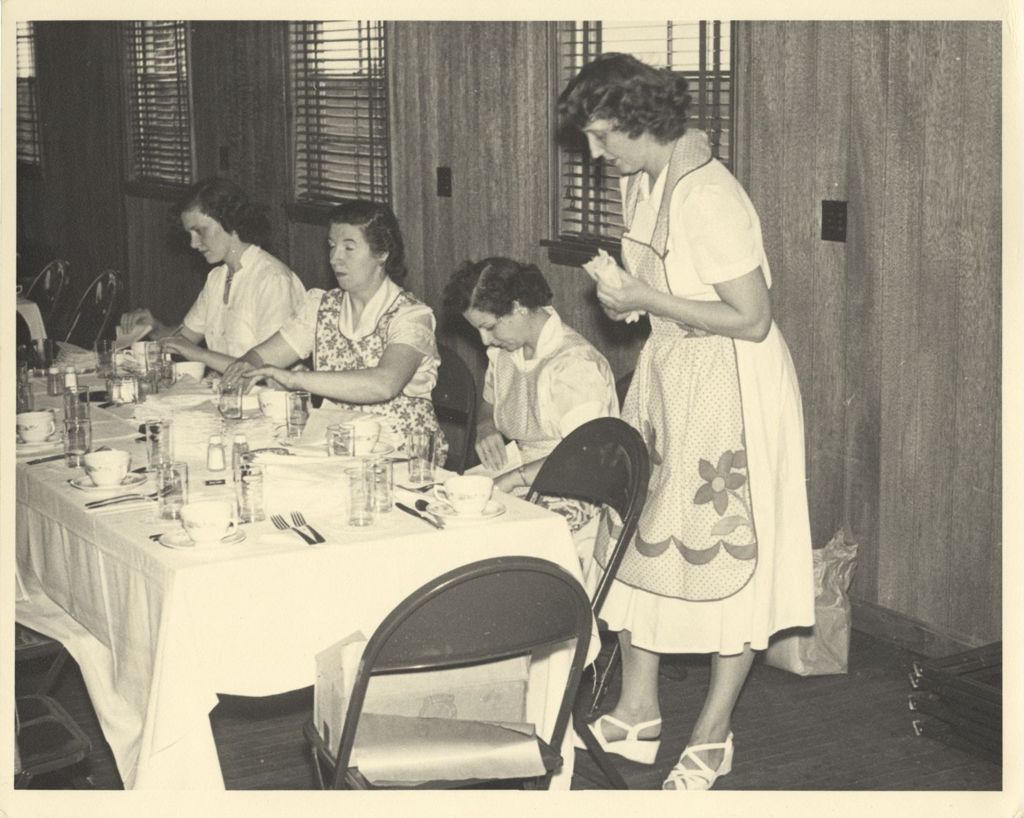 Women prepare a dinner table at the Hamburg Athletic Association