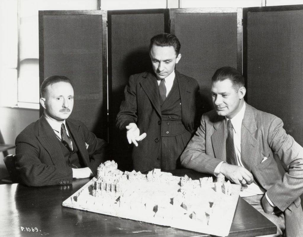 Miniature of Three unidentified men looking over the diorama of the Century of Progress Belgian Village.