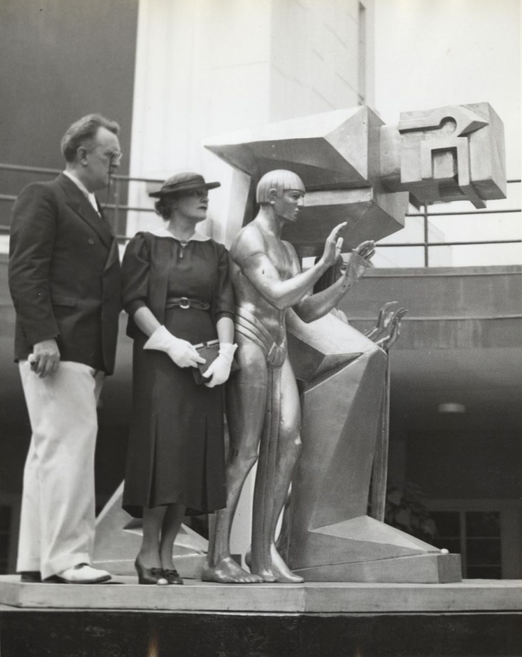 Miniature of Louise Lentz Woodruff standing next to the sculpture she designed for the Fountain of Science, located in front of the main entrance to the Hall of Science.