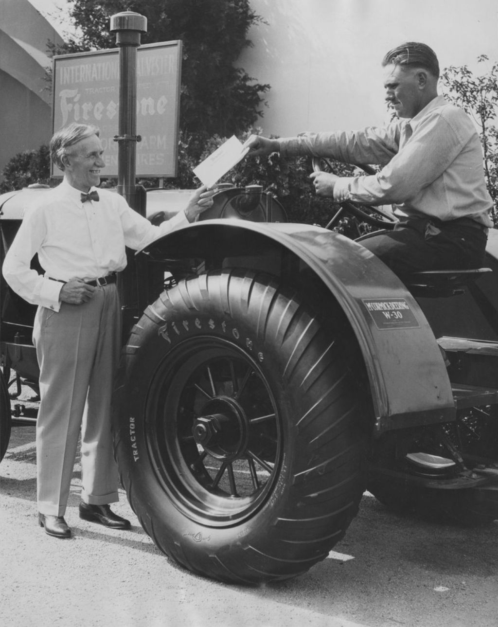 Harvey Firestone presents a farmer with a complete set of tractor wheels and tires at the Fair