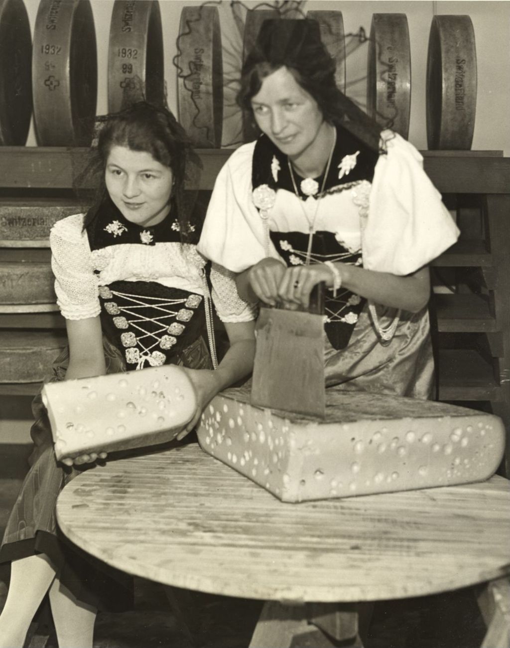 Entertainers at the Swiss Village cutting a piece of Swiss cheese to tempt visitors appetites