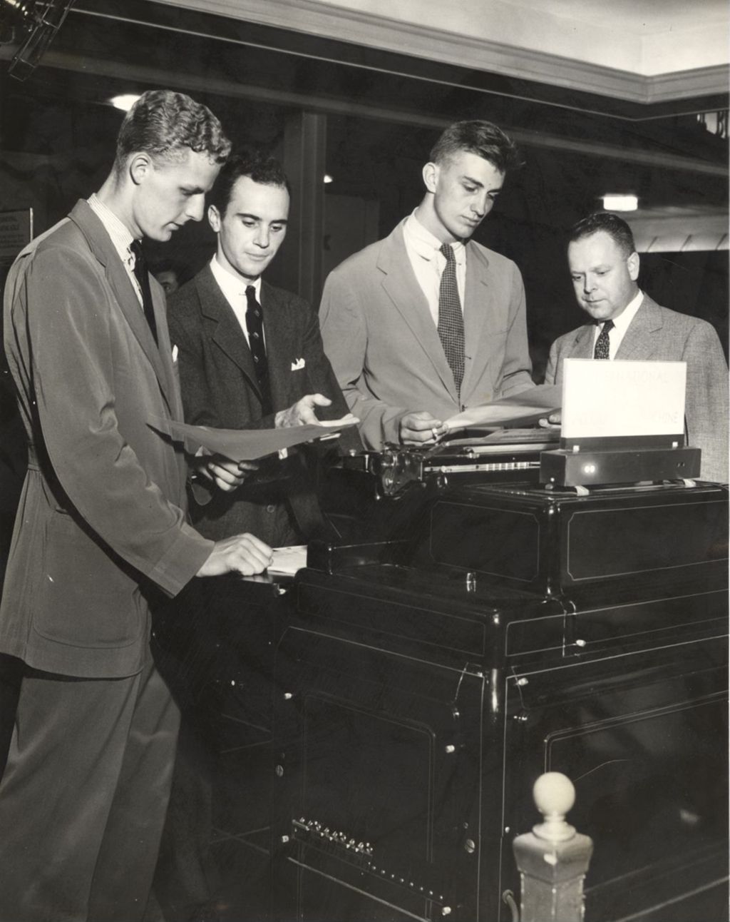 Franklin D. Roosevelt, Jr. inspects a report at the International Business machines exhibit