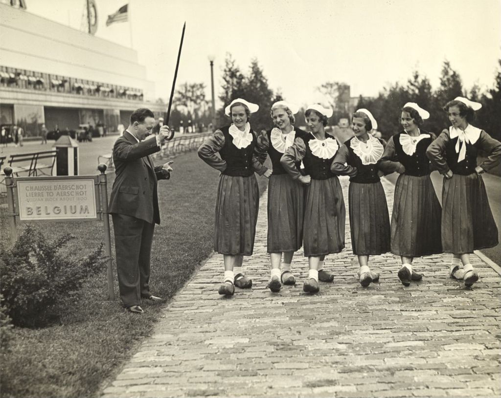 Miniature of Georges N. Potie about to start a wooden-shoe race between dancing girls of the Belgian Village