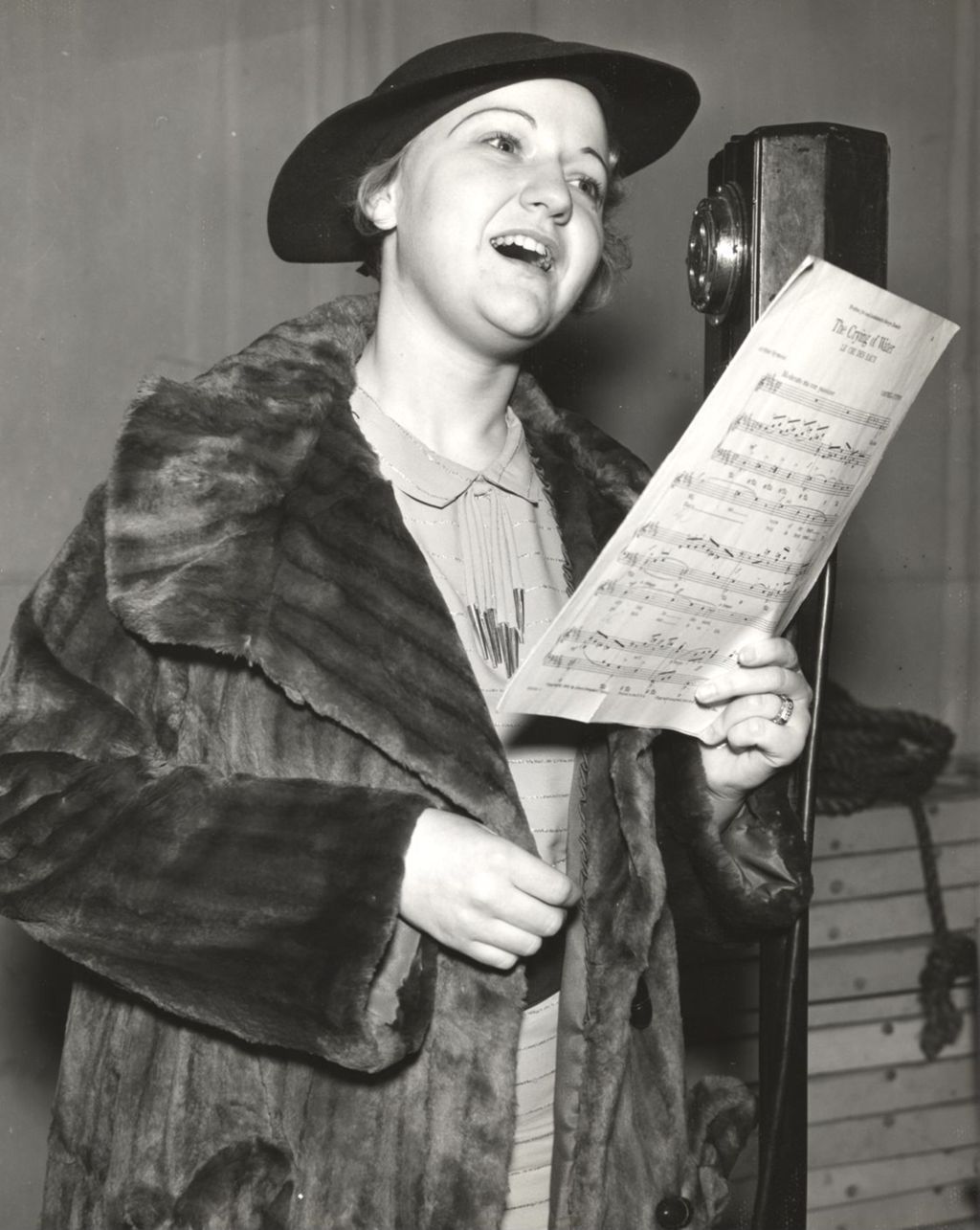 Miniature of Zeta Newell, of Oak Park, IL., a winner of the Century of Progress Opera Contest, sings in front of the microphone