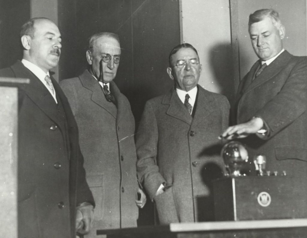 Miniature of W.O. Batchelder, president of the Electric Association of Chicago, activates the lights of the Electrical Group during the official dedication