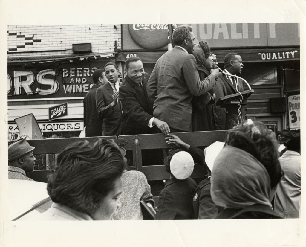 Reverend Martin Luther King Jr. greeting people from the back of a truck, ca. 1966.