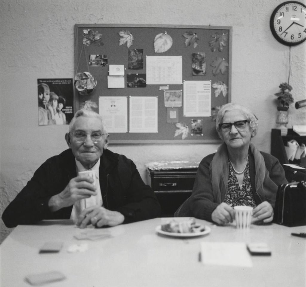 Two seniors with food and drink at a senior center affiliated with Hull-House