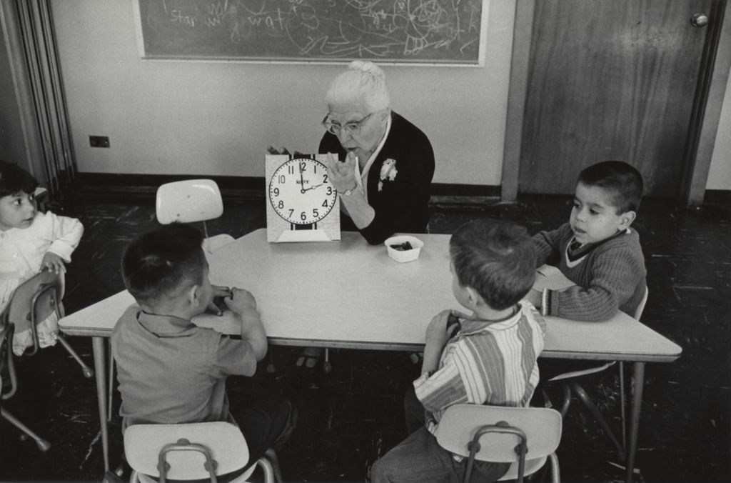 Miniature of Senior woman teaching children how to tell time
