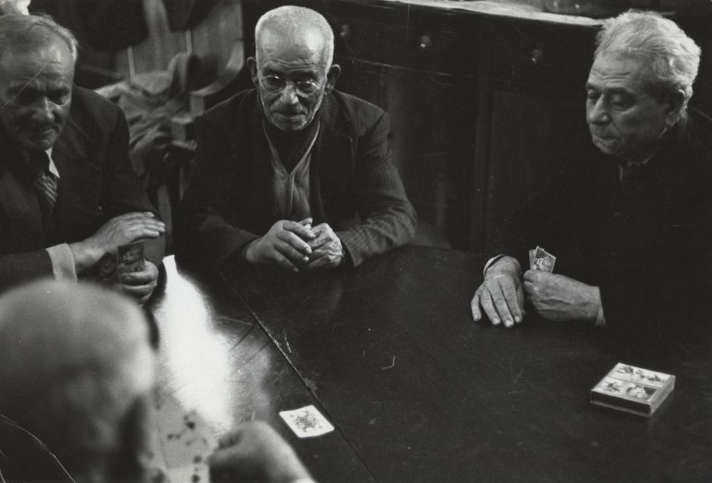 Four men, members of the "Young Old Timers" sitting and playing cards at a table