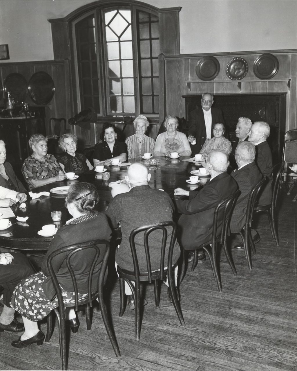 Members of the Hull-House senior citizens club "Young Old Timers" having coffee or tea around a table in the Residents Dining Hall