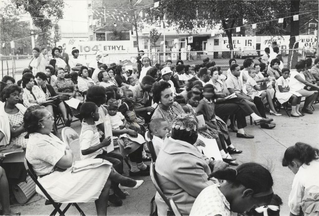 Adults and children seated outdoors at the closing activity for Parkway Community House's 1962 day camp