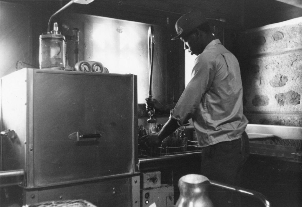 Miniature of Young man rinsing silverware in the kitchen at the Hull-House camp in Wisconsin
