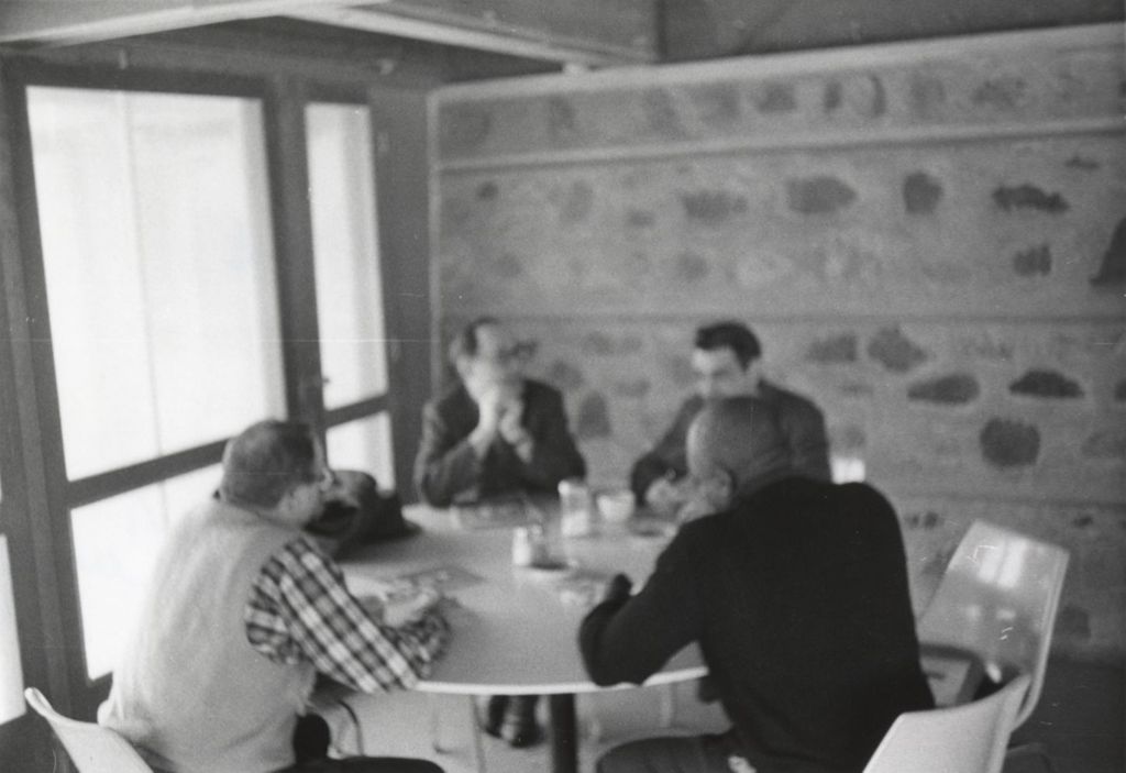 Four men sitting at a table at the Hull-House camp in Wisconsin