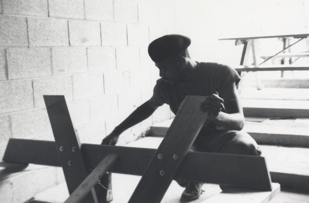 Young man working on a wood structure at the Hull-House camp in Wisconsin