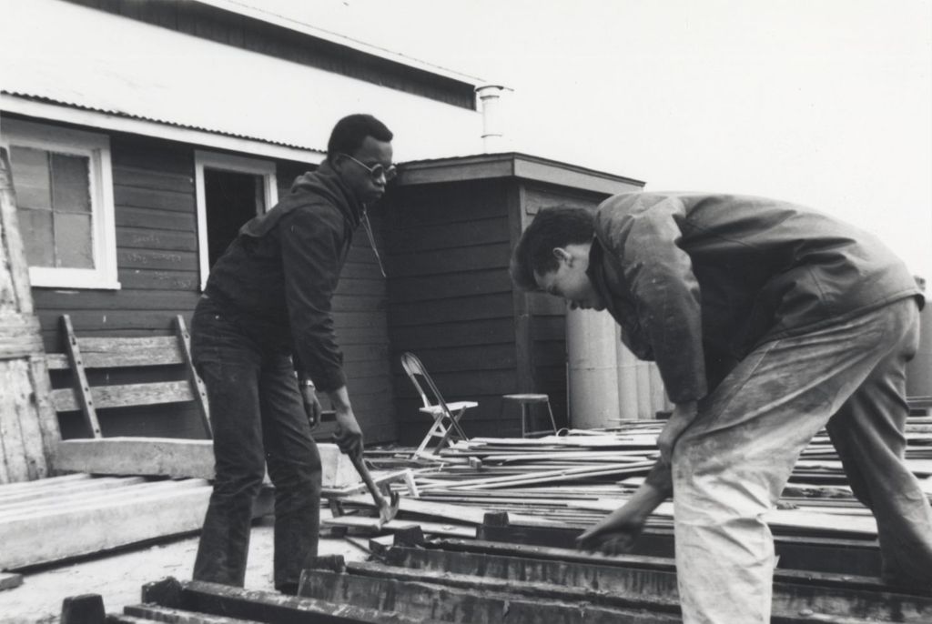 Two young men working outdoors at the Hull-House camp in Wisconsin
