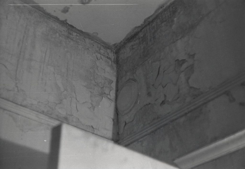 Corner of a ceiling with cracked plaster and water damage