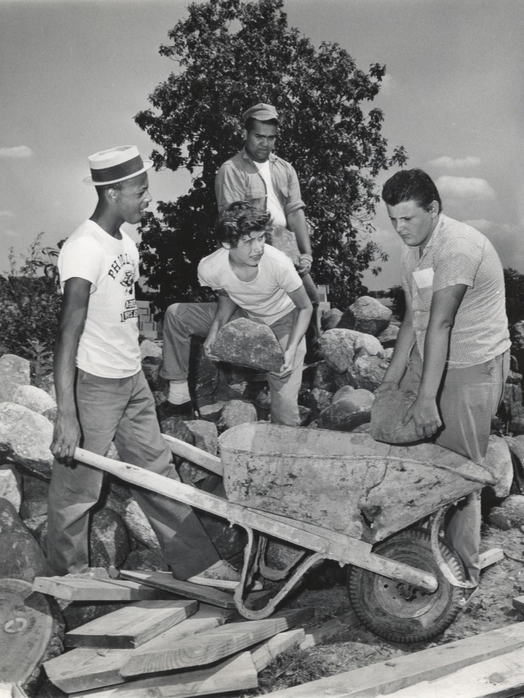 Young men load rocks into a wheelbarrow at the Hull-House work camp in Wisconsin