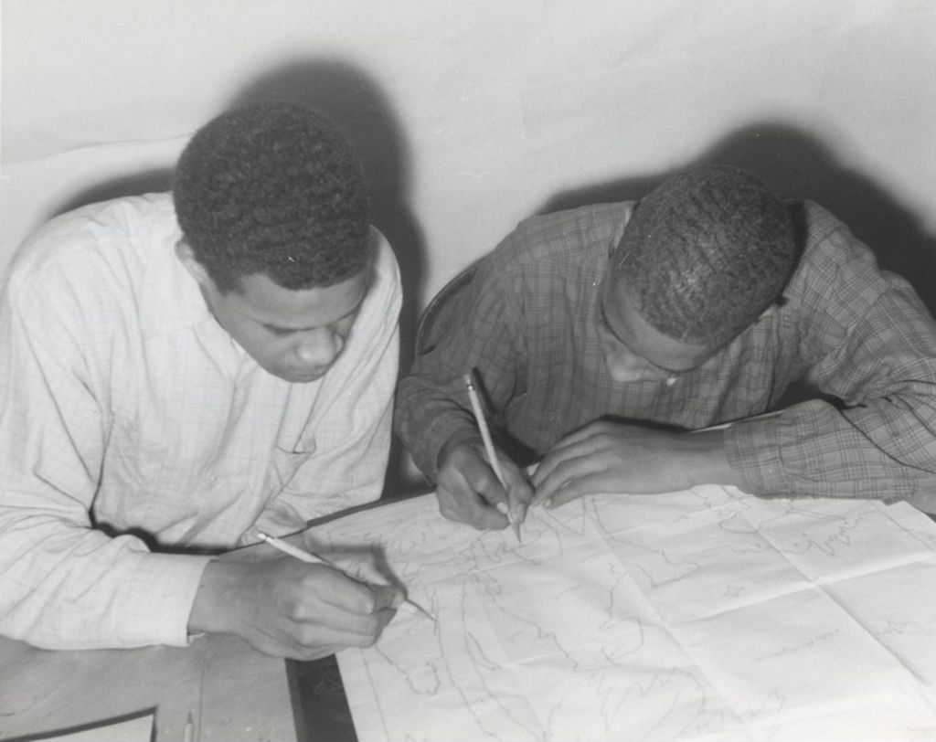 Two young men drawing or tracing on a piece of paper at Parkway Community House