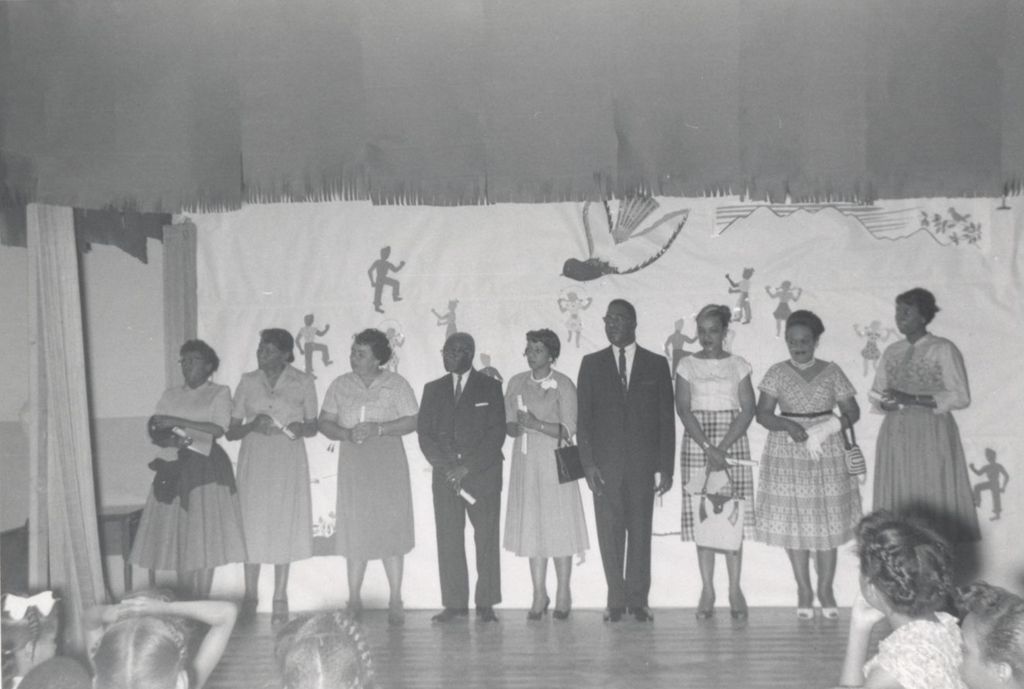 Nine adults lined up on stage at an event at Parkway Community House