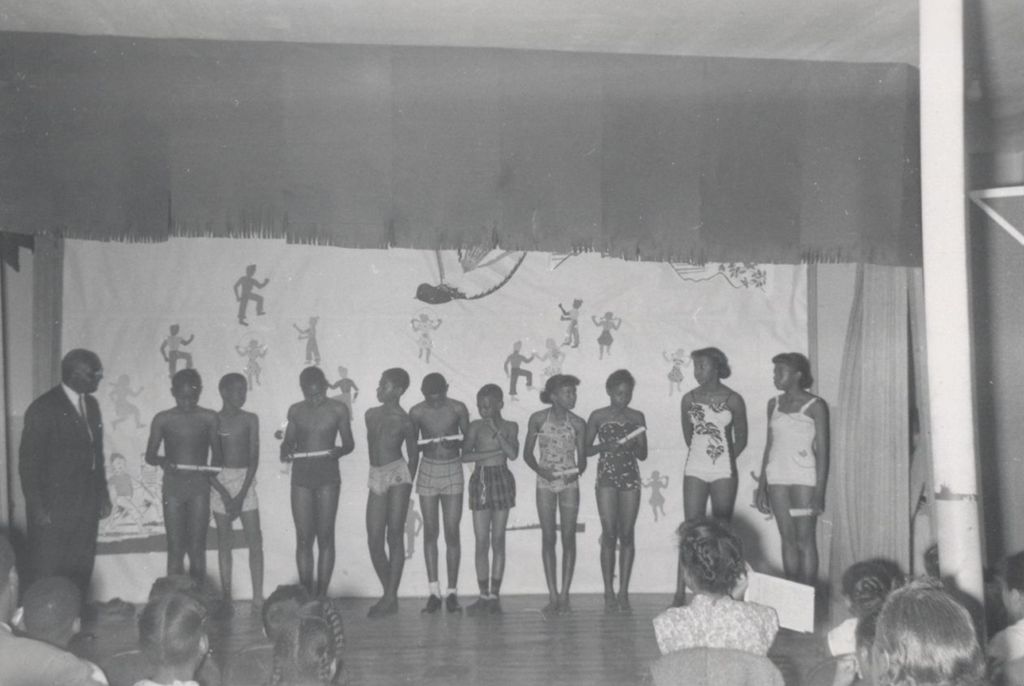Ten young people on stage in swimsuits at an event at Parkway Community House