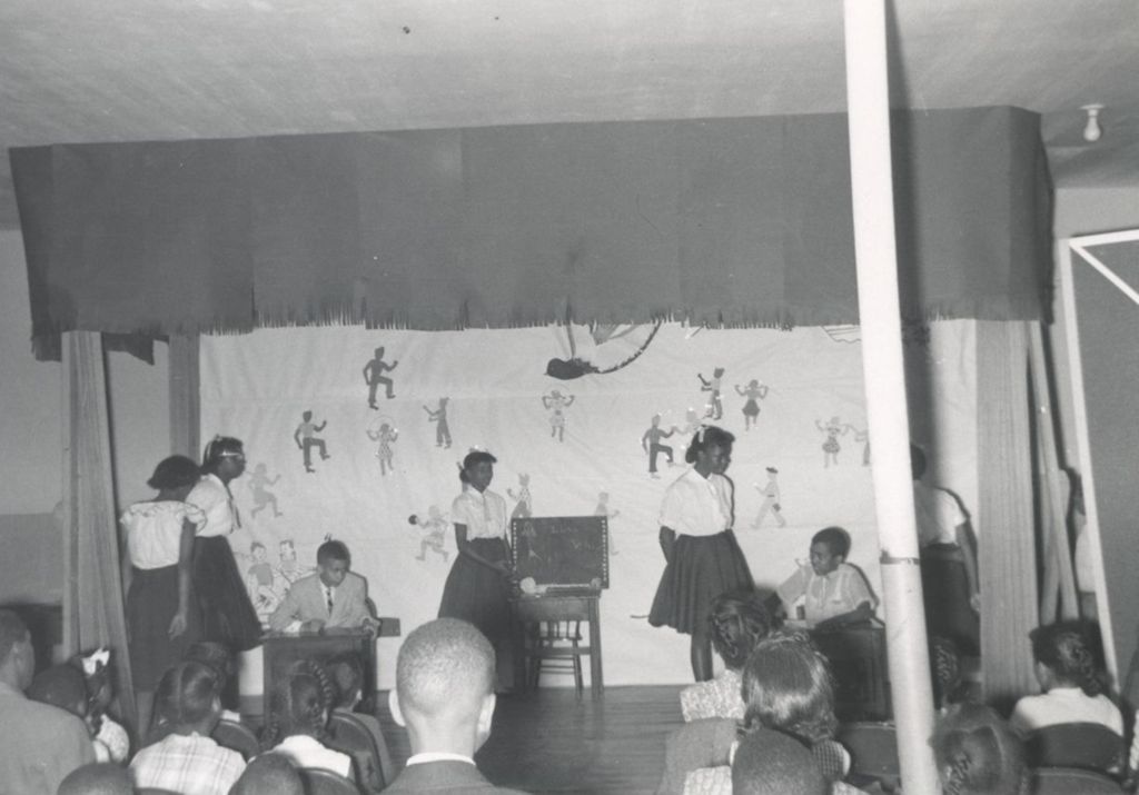 Young people performing a skit on stage at an event at Parkway Community House