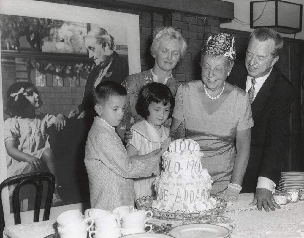 Miniature of Two children cut into a cake celebrating the centennial of Jane Addams' birth; looking on are three adults: Jane Addams' grand niece, Congresswoman Marguerite Stitt Church, and the president of the Hull-House board