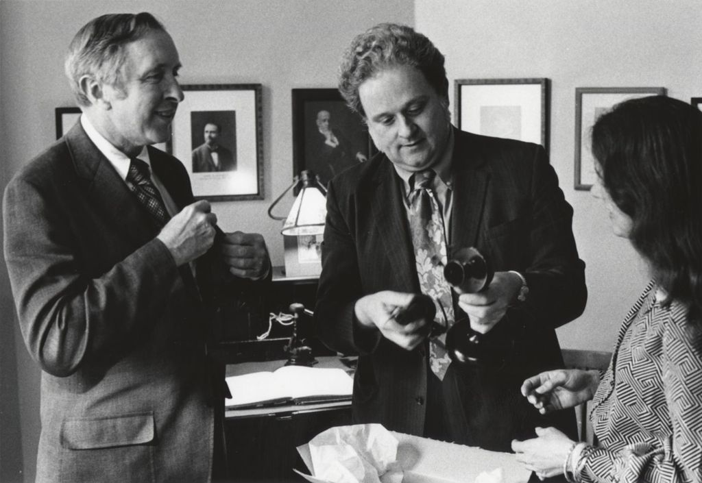 Man holding an antique telephone at Jane Addams Hull-House Museum, flanked by Hull-House Association board member John Trutter and museum curator Mary Lynn McCree (Bryan)