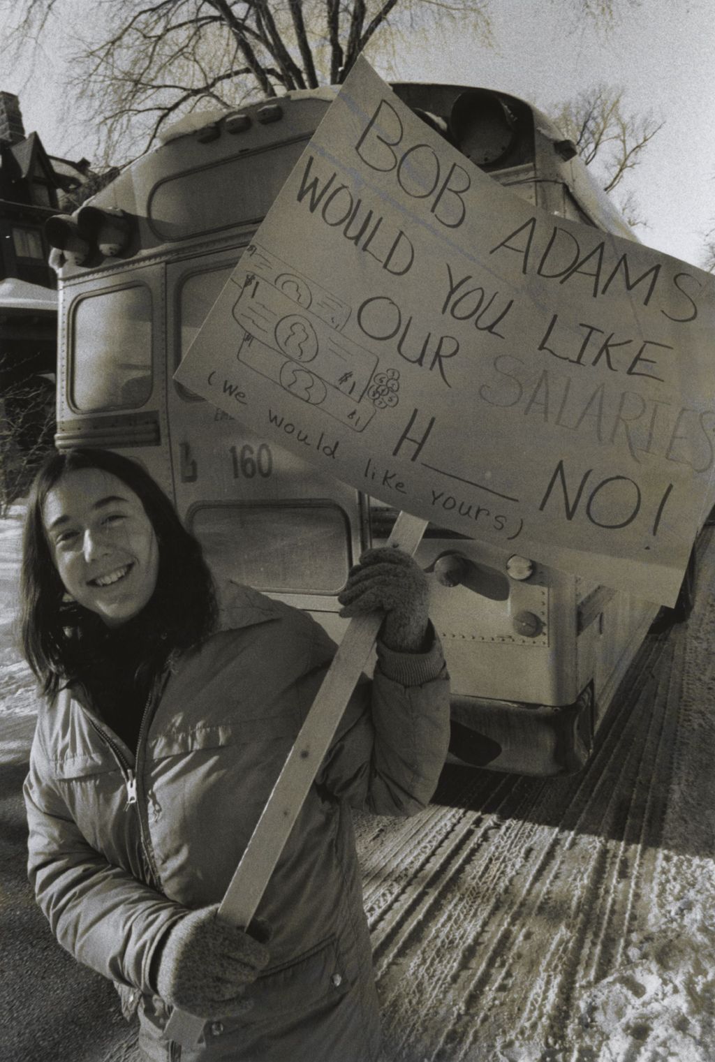 Woman holding picket sign during a union protest at Jane Addams Hull-House Association Executive Director Bob Adams' house