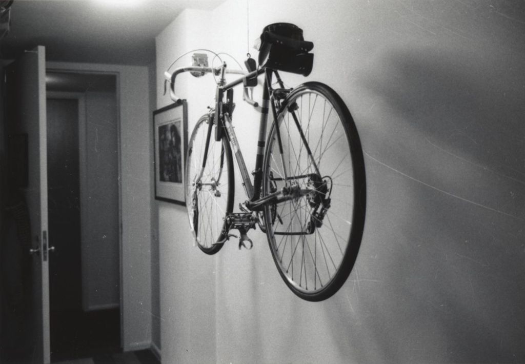 Bicycle suspended from ceiling next to a wall