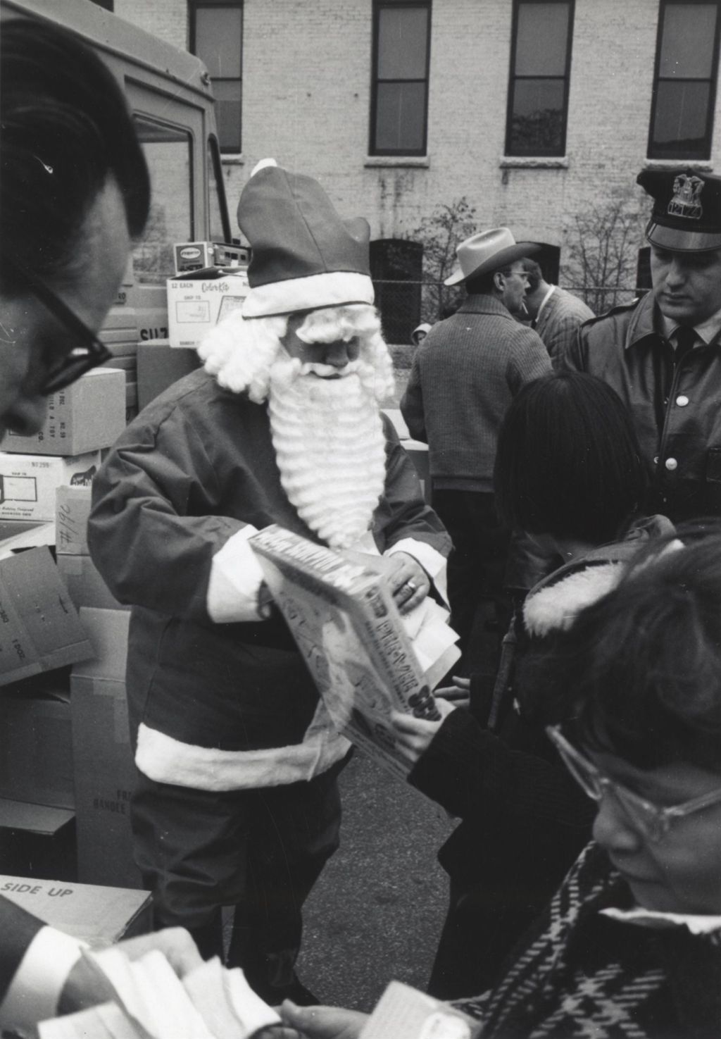 Santa Claus handing toy to child at a Hull-House Christmas toy giveaway