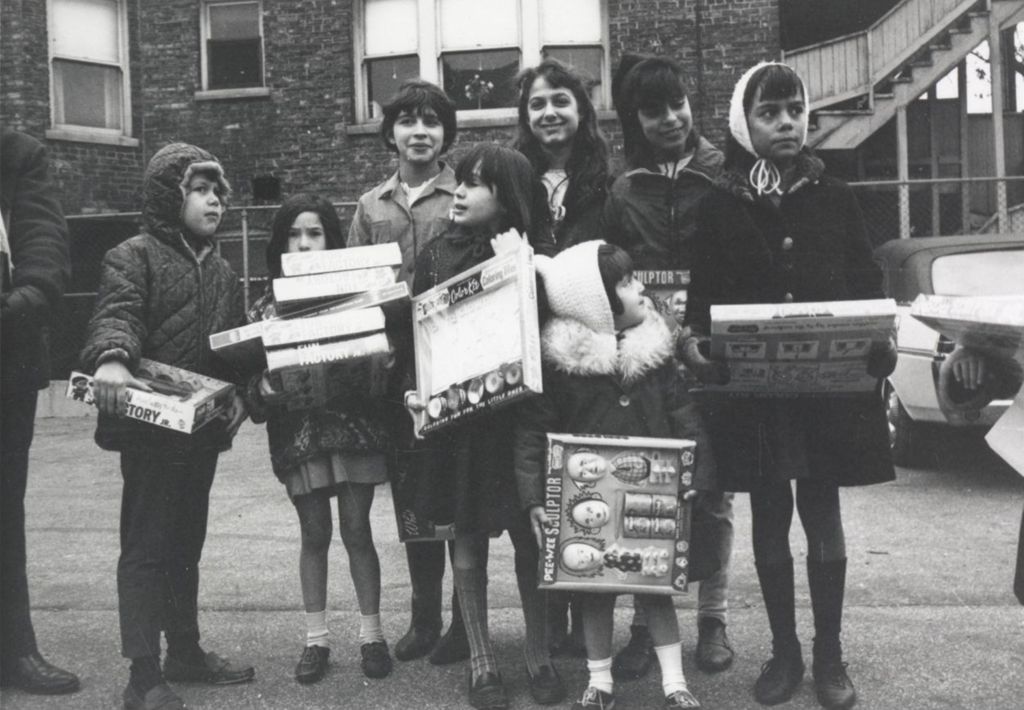 Children pose with gifts at a Hull-House Christmas toy giveaway