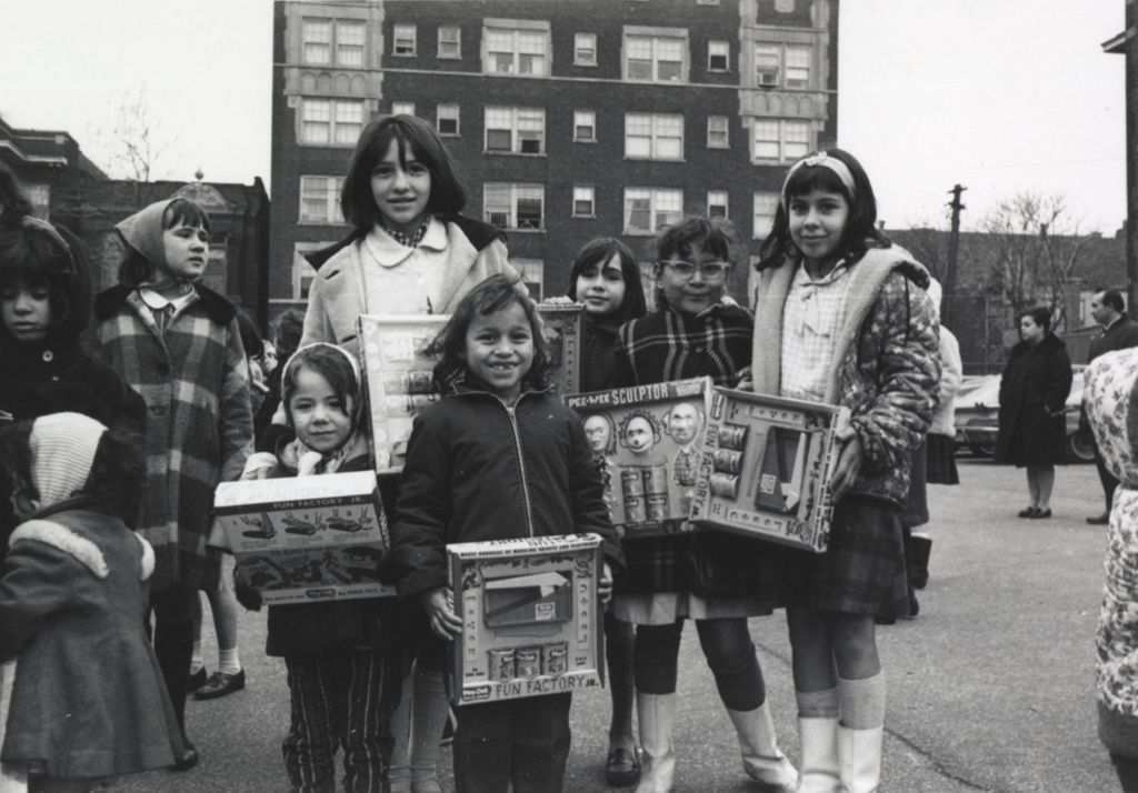 Girls pose with gifts at a Hull-House Christmas toy giveaway
