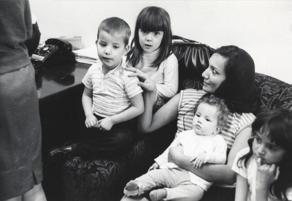 A woman and four young children on a couch during a Hull-House Christmas party at the Jane Addams Center
