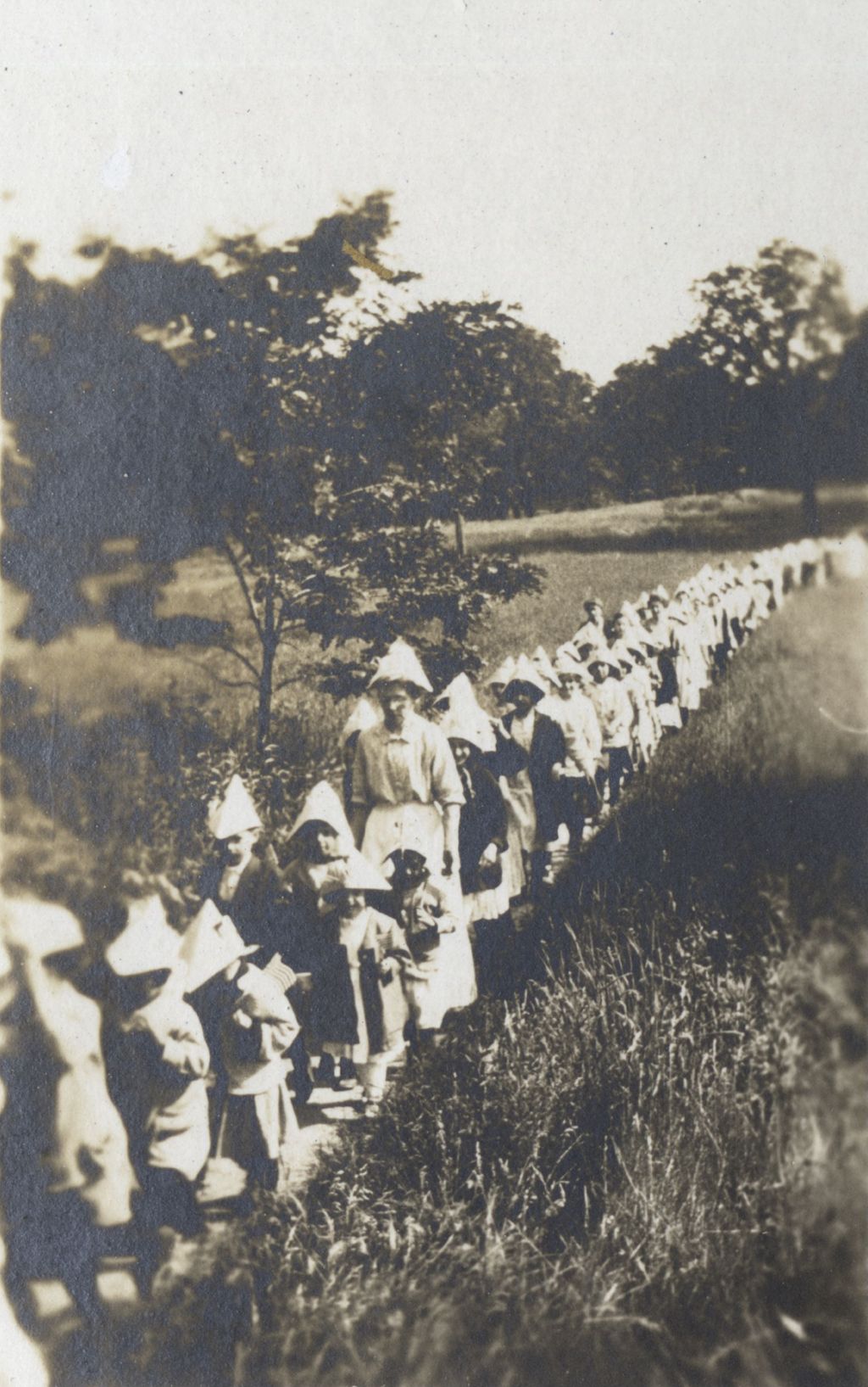 Miniature of Women and children in paper hats in procession