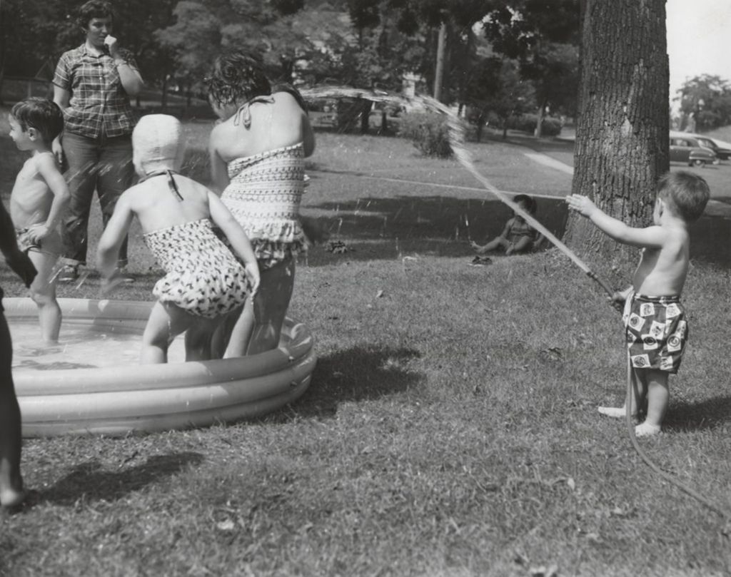 Children being sprayed in wading pool