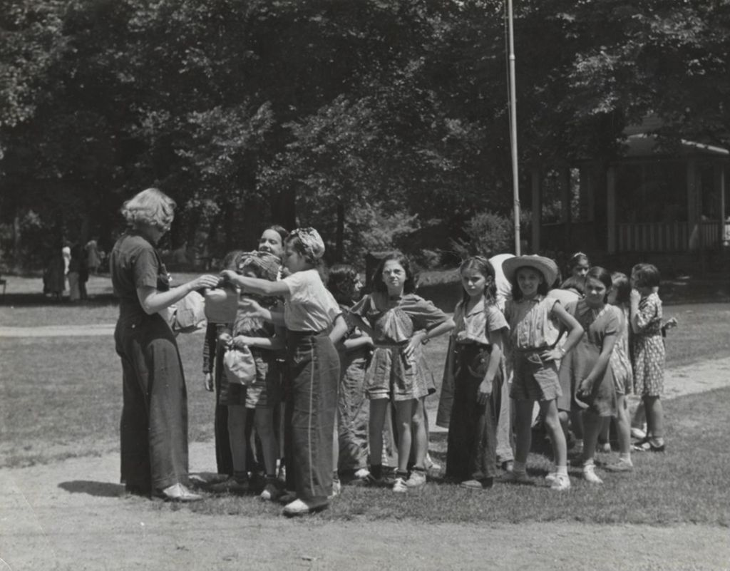 Girls receiving picnic bags from Miss Smith