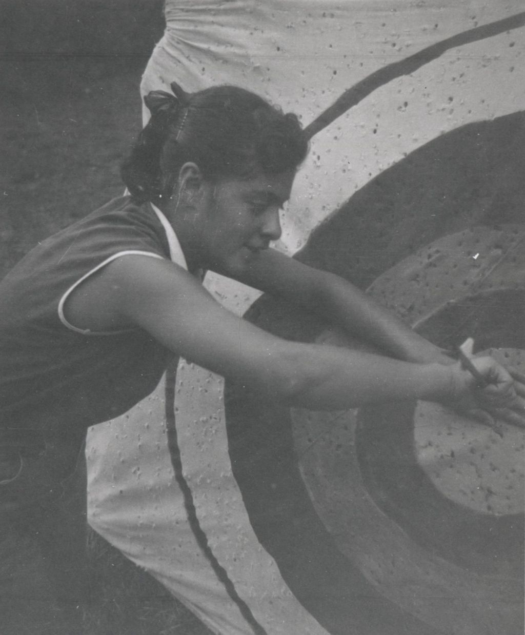 Pulling arrow from archery target, facing right