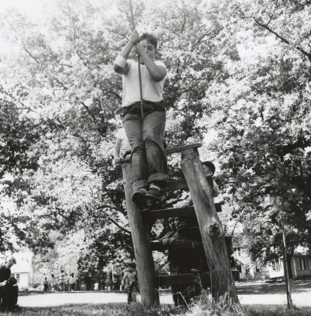 Boy on rope swing at Camp French