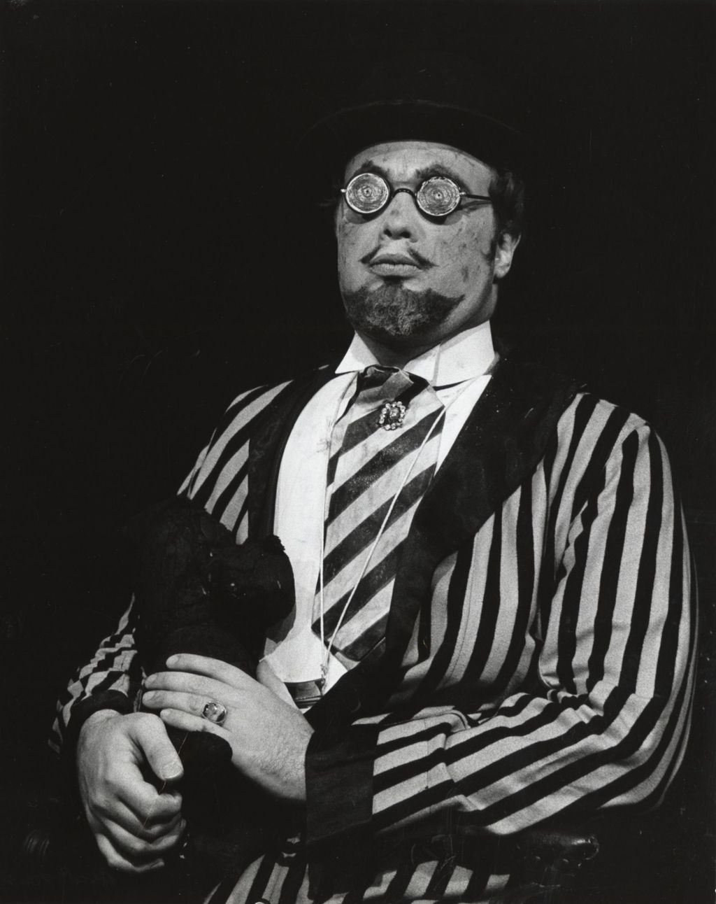 Unidentified actor in loud striped suit on stage in a production of "The Threepenny Opera" at Hull-House Theater