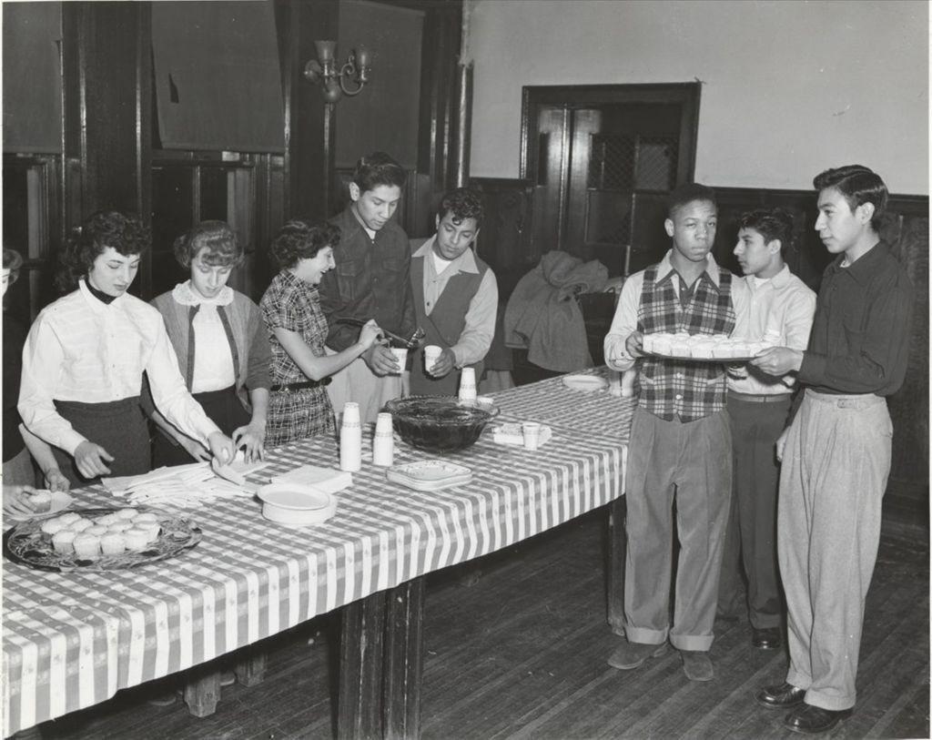 Young people at a refreshment table during a Hull-House social event