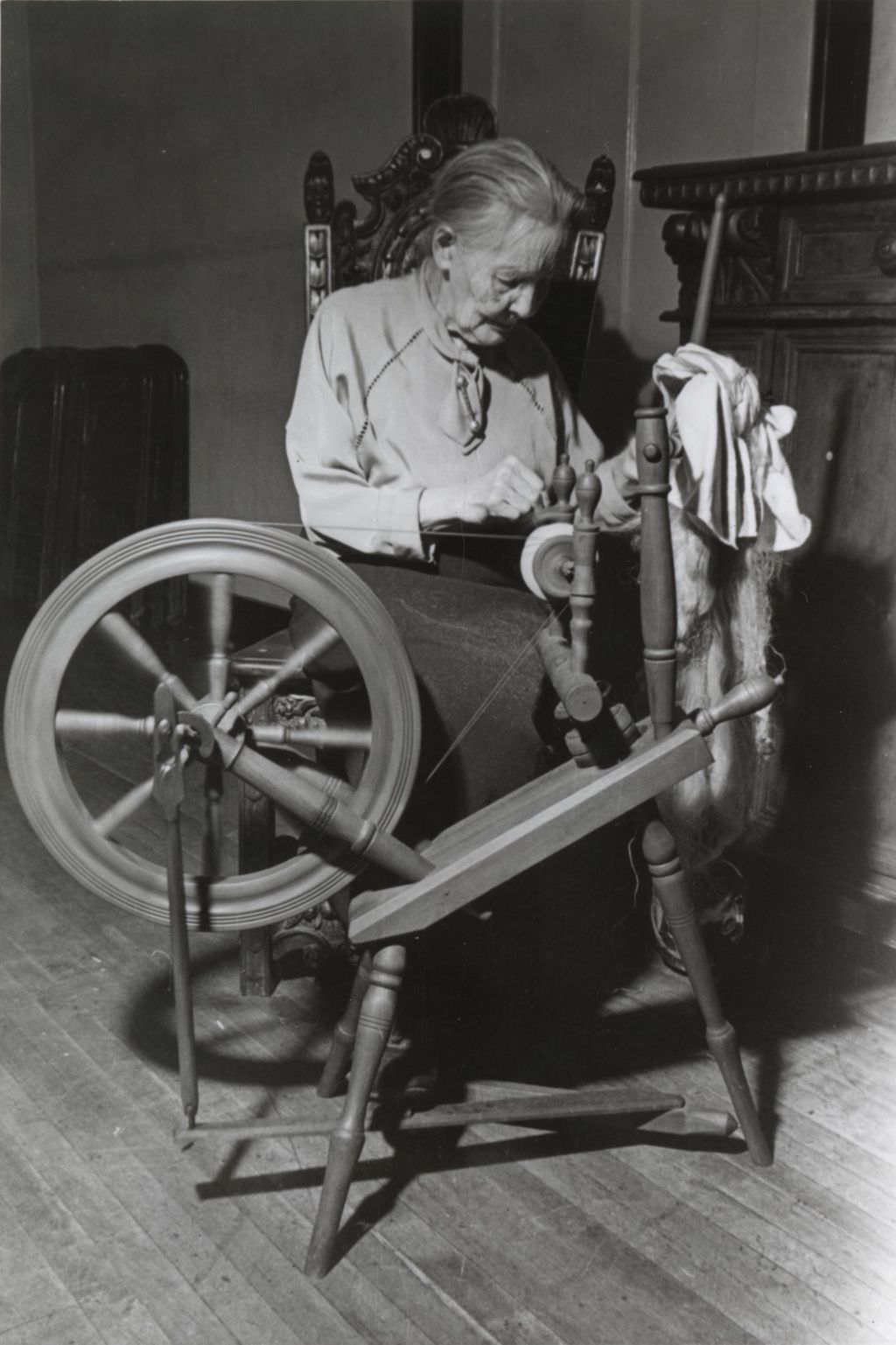 Woman at a spinning wheel during Hull-House 1951 Spring Carnival