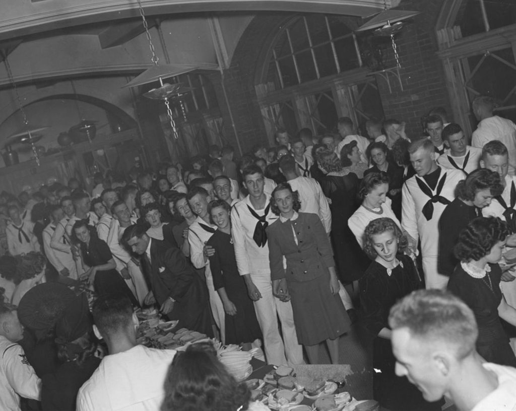 United States Navy sailors and civilians - mostly women - fill the Hull-House coffee house during an "Entertaining the Navy" event