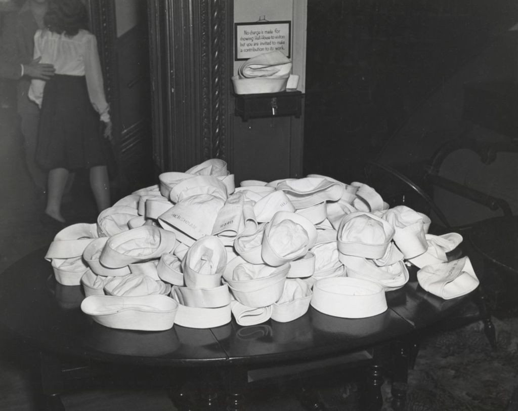Miniature of Sailor hats in a pile on a table at Hull Mansion during an "Entertaining the Navy" event