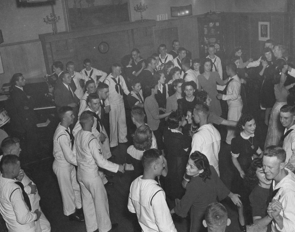 Civilian women and United States Navy sailors dancing and socializing in the Hull-House Residents' Dining Hall during an "Entertaining the Navy" event